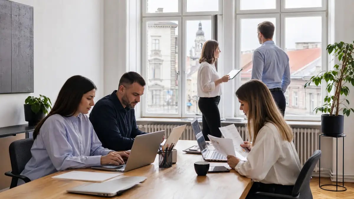 A professional team working in a modern Eastern European office with historic architecture beyond