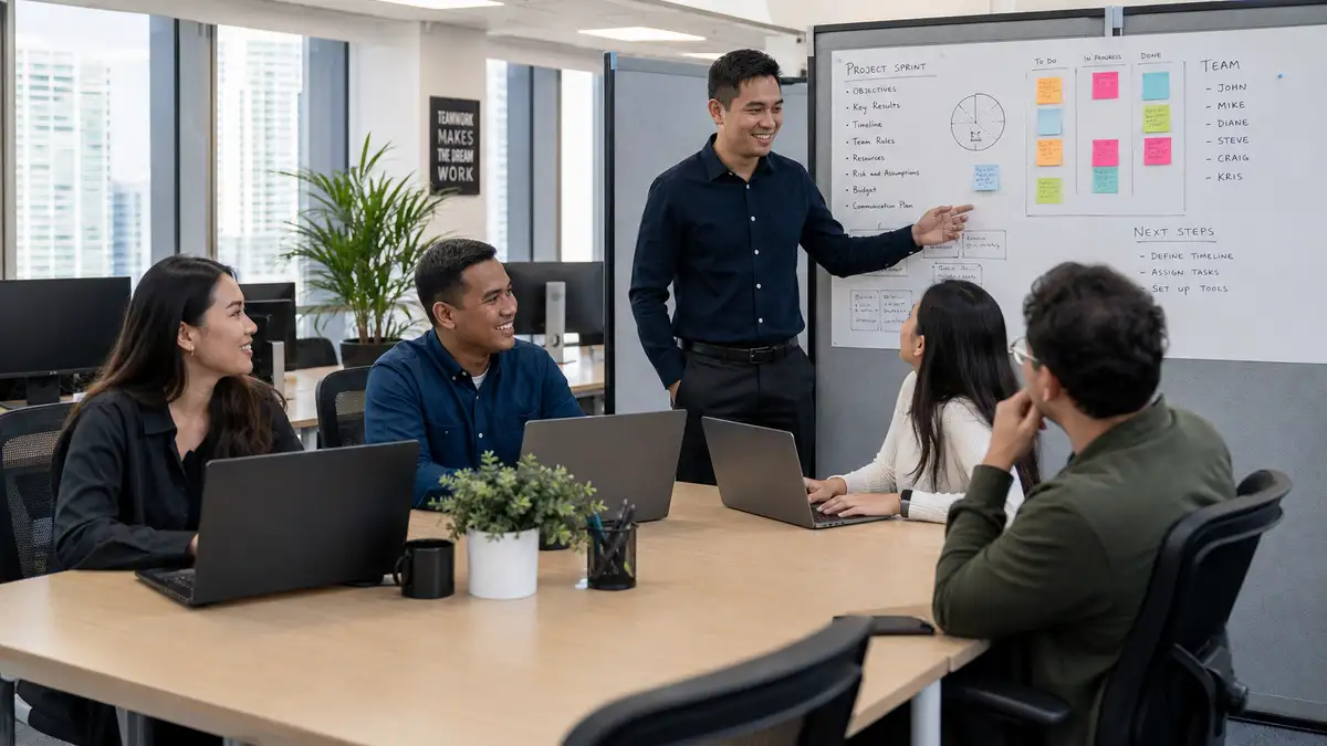 An embedded offshore team working together with a local team leader in a modern managed office, illustrating the embedded offshore team model in practice